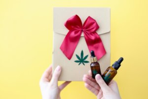 female-hands-are-holding-gift-box-bottle-marijuana